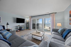 a living room with a couch and a table at Tranquility By The Sea-Oceanside Condo in Salter Path