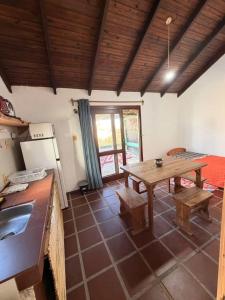a living room with a table and a kitchen at Mar y Sal in Punta Del Diablo