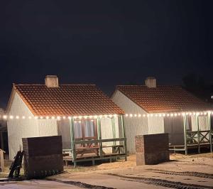 two huts with lights on them at night at Mar y Sal in Punta Del Diablo