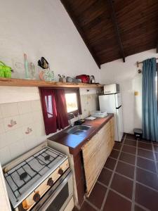a kitchen with a stove and a sink in it at Mar y Sal in Punta Del Diablo +2 photos