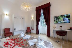 a bedroom with a bed with red chairs and a chandelier at Maison 900 in Tivoli