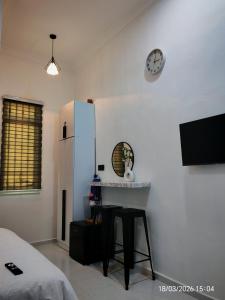 a kitchen with a table and a refrigerator and a clock at Zaifaa Beach Inn in Setiu
