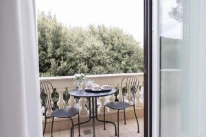a table and chairs on a balcony with a window at Maison 900 in Tivoli