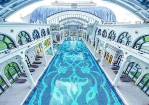 an indoor swimming pool in a building with a ceiling at Na homes coffee in Binh Hai