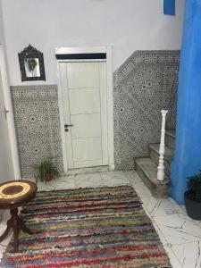 a room with a door and a rug and a stairway at maison bleu hajja in Tangier +22 photos