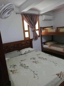 a bedroom with a bed and two bunk beds at Casa madrigueña rincón del mar in Rincón