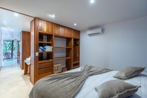 a bedroom with a bed and a book shelf at Private Jungle Villa with Full Kitchen & Pool Access in Tulum +26 photos