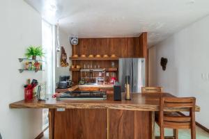 a kitchen with a large wooden island in a room at Private Jungle Villa with Full Kitchen & Pool Access in Tulum
