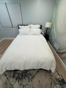 a bed with white sheets and pillows in a room at GorgeousWestwood in Westwood