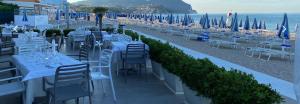 a row of tables and chairs on a beach at Conero Casa - Marcelli di Numana in Piazzale Tremiti 7 con Parcheggio Esclusivo in Marcelli