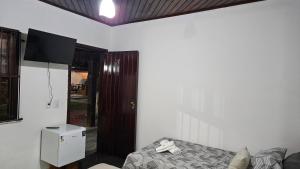 a room with a bed and a tv in it at Casa da Passagem in Cabo Frio
