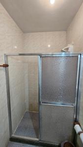 a shower with a glass door in a bathroom at Casa da Passagem in Cabo Frio