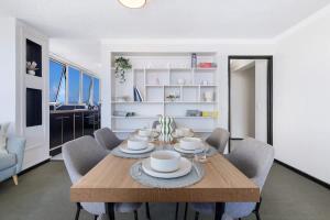 a dining room with a wooden table and chairs at Salt & Sky Arcade - Sleeps 12 in Gold Coast