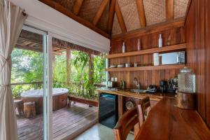 a kitchen with a tub and a table and chairs at Luxury Jungle Suite with Private Jacuzzi & Cenote Pool View in Chemuyil