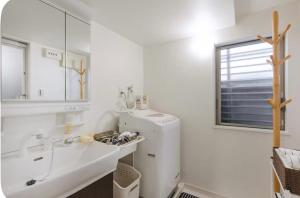 a white kitchen with a sink and a refrigerator at 嵐lan in Kyoto