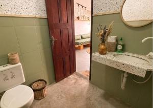 a bathroom with a toilet and a sink and a mirror at Pousada Nativa Jeri in Jericoacoara