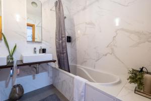 a bathroom with a tub and a sink and a bath tub at A casa da Girafa in Ponta Delgada +31 photos