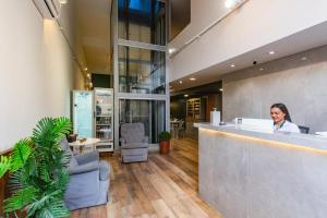 a woman sitting at a counter in a lobby at Hotel Morada Del Este in Canoas +171 photos