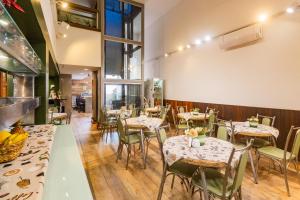 a restaurant with tables and chairs in a room at Hotel Morada Del Este in Canoas