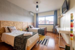 a hotel room with two beds and a desk at A casa da Girafa in Ponta Delgada