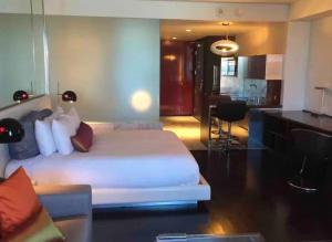 a bedroom with a large white bed and a kitchen at Palms Place Condo with strip view in Las Vegas +5 photos