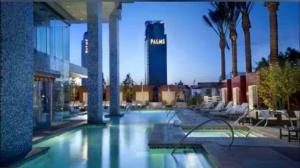 a large swimming pool in a building with palm trees at Palms Place Condo with strip view in Las Vegas
