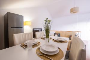 a white table with plates and napkins on it at A casa da Girafa in Ponta Delgada
