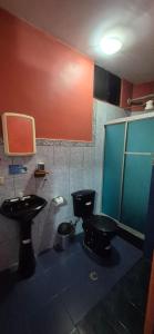 a bathroom with a black toilet and a sink at Casa de Lewis in San Cristóbal +19 photos