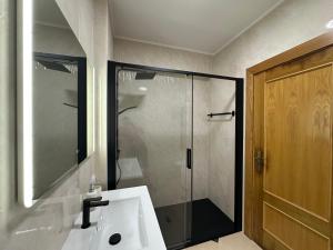 a bathroom with a shower and a white sink at Sun & Wave Apartment in Peniche +48 photos