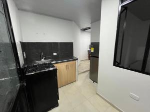 a small kitchen with a sink and a stove at El Rincon de Teresita in Villavicencio