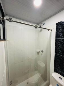 a glass shower in a bathroom with a toilet at El Rincon de Teresita in Villavicencio