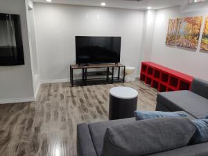 a living room with a couch and a flat screen tv at Suite! Separate Entry, 1 Parking in Newmarket