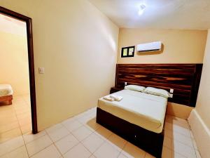 a bedroom with a bed with a wooden headboard at Casa Brisas in Puerto Escondido +2 photos