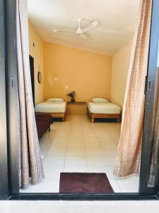 a room with two beds and a window with curtains at Casa Brisas in Puerto Escondido