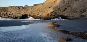 a view of a beach with a tunnel in the rocks at Hotel Salinas São Jorge in São Filipe