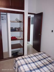 a bedroom with a closet with a bed and a mirror at Comfortable, bright and compact in Tembladera