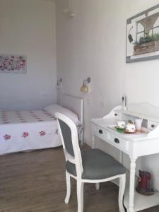 een wit bureau en een stoel in een kamer met een bed bij La Terrazza Sui Miracoli in Pisa