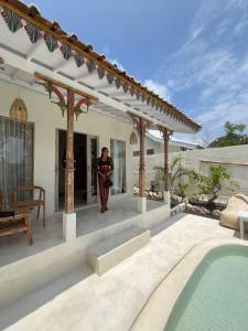 a woman walking into a house with a swimming pool at Romantic private villas Buvillas nusa penida in Nusa Penida