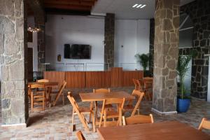a restaurant with wooden tables and chairs and a screen at Hotel Tierras Blancas in Valle de Bravo