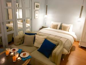 a bedroom with a bed and a couch with a table at O Quinto Esquerdo in Lisbon