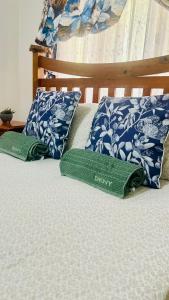 a bed with two green pillows on it at Primrose Guest Houses in Nuku‘alofa