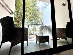 a view of a balcony with chairs and a table at Phuket Muay Thai Hotel Rawai Beach in Rawai Beach