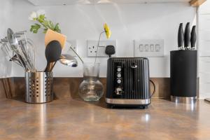 a kitchen counter with a toaster and other kitchen utensils at 3-Bedrm, Parking, Soccer Table, Sleeps 7 in Cannock