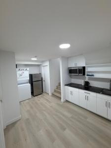 a kitchen with white cabinets and appliances in a room at Granite Grove Suite in Winnipeg +17 photos