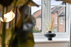 a vase sitting on a window sill with a plant at 3-Bedrm, Parking, Soccer Table, Sleeps 7 in Cannock