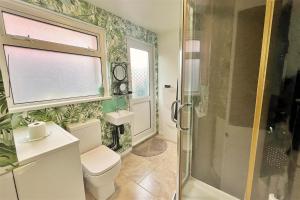 a bathroom with a toilet and a glass shower at Glebe Summer House in Osmington