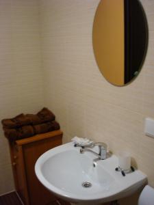W łazience znajduje się umywalka i lustro. w obiekcie Отель Гармония w mieście Dniepr