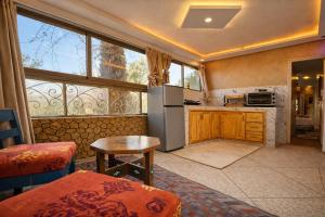 a kitchen with a refrigerator and a table in a room at Maison Gourdia in Zouiyya
