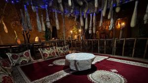 a room with a table on a red carpet at Maison Gourdia in Zouiyya