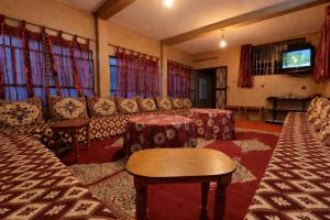 a living room with couches and a flat screen tv at Maison Gourdia in Zouiyya